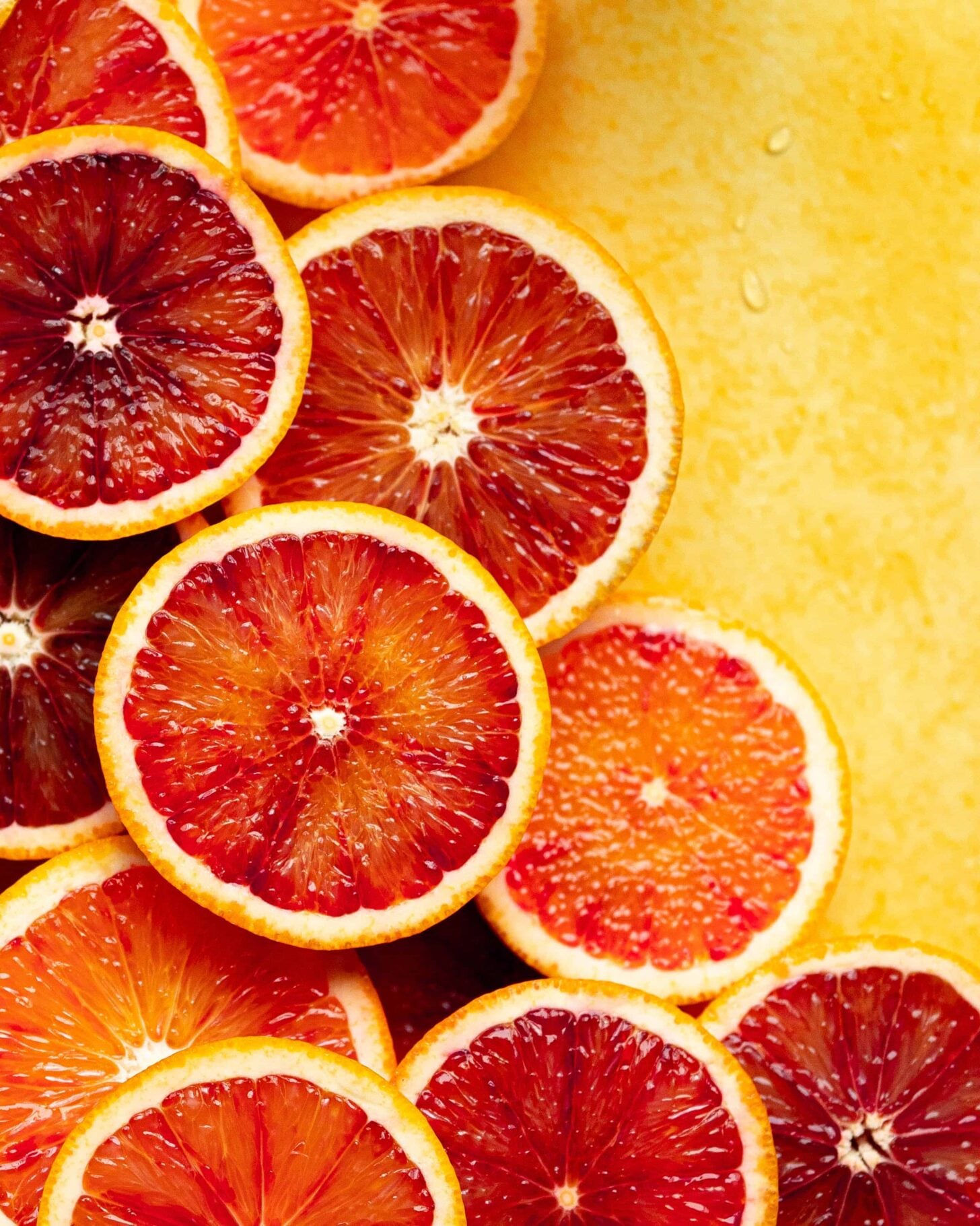 Blood orange slices on a yellow background