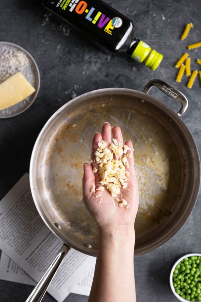 A hand with chopped garlic