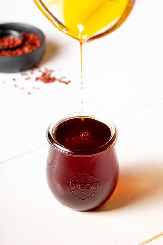 Achiote oil pouring into a jar
