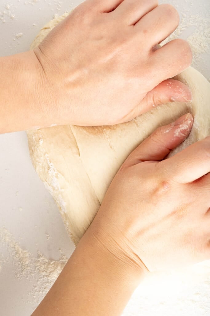 Two hands kneading dough