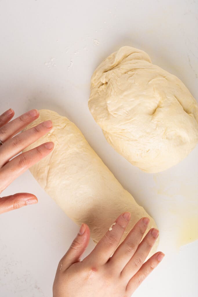 Hands rolling out bread dough