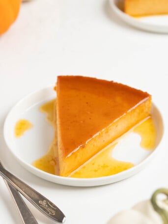 Sliced pumpkin flan on a white plate.