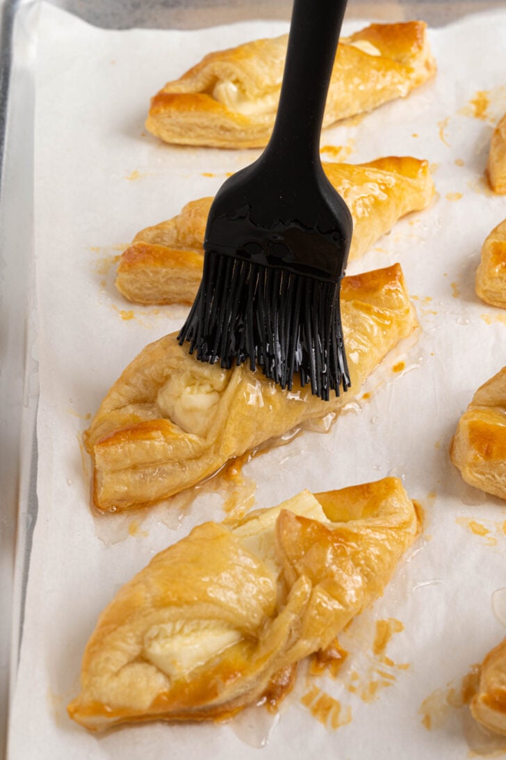Quesitos being brushed with simple syrup.