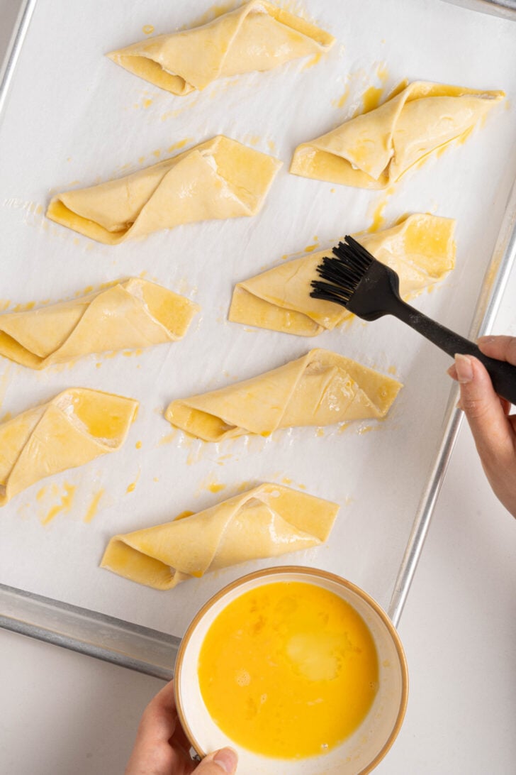 Quesitos being brushed with egg wash.