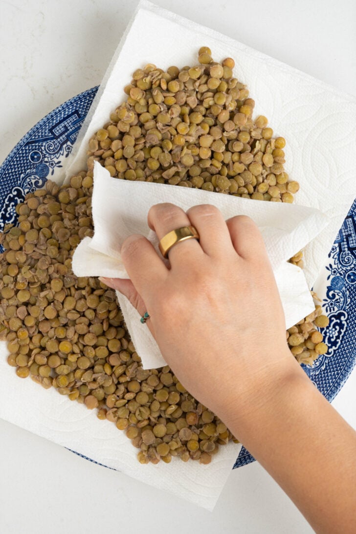 The cooked lentils are being tapped dry.