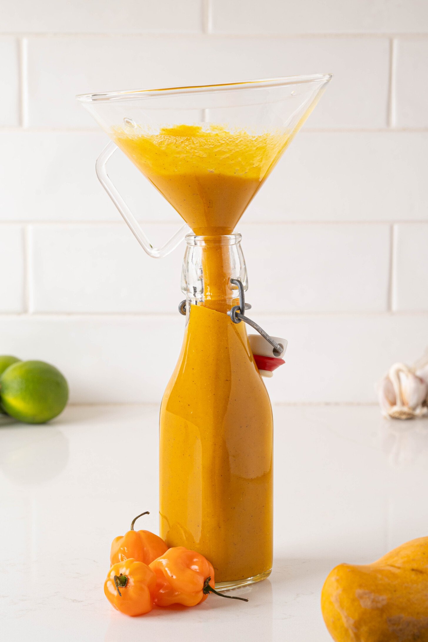 The hot sauce is pouring into a bottle.