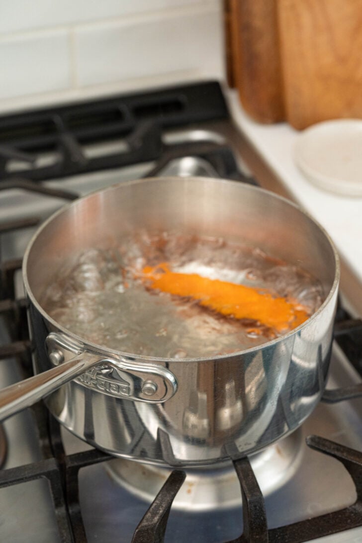 A carrot boils in water.
