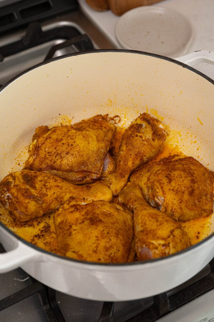 Seasoned chicken searing in a pot.