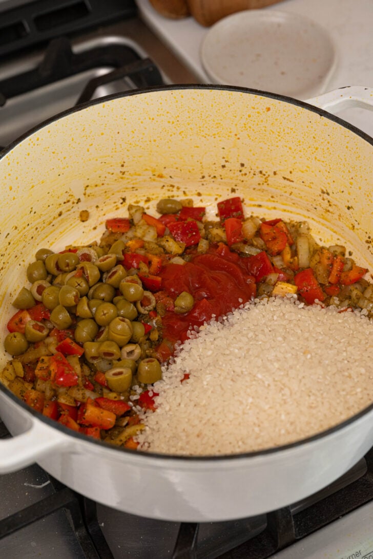 A pot with rice, olives, and more.