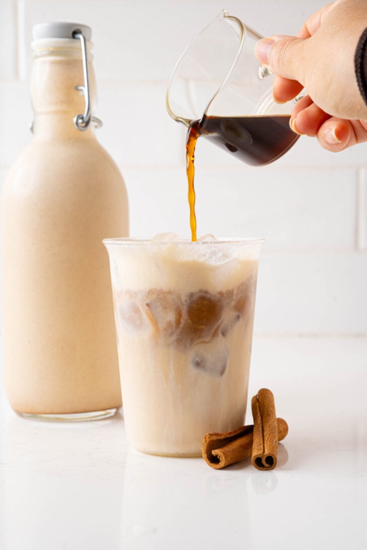 Espresso pouring into a coquito latte.