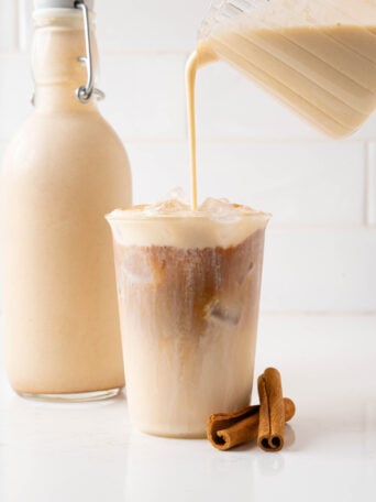 Coquito pouring over a coquito latte.