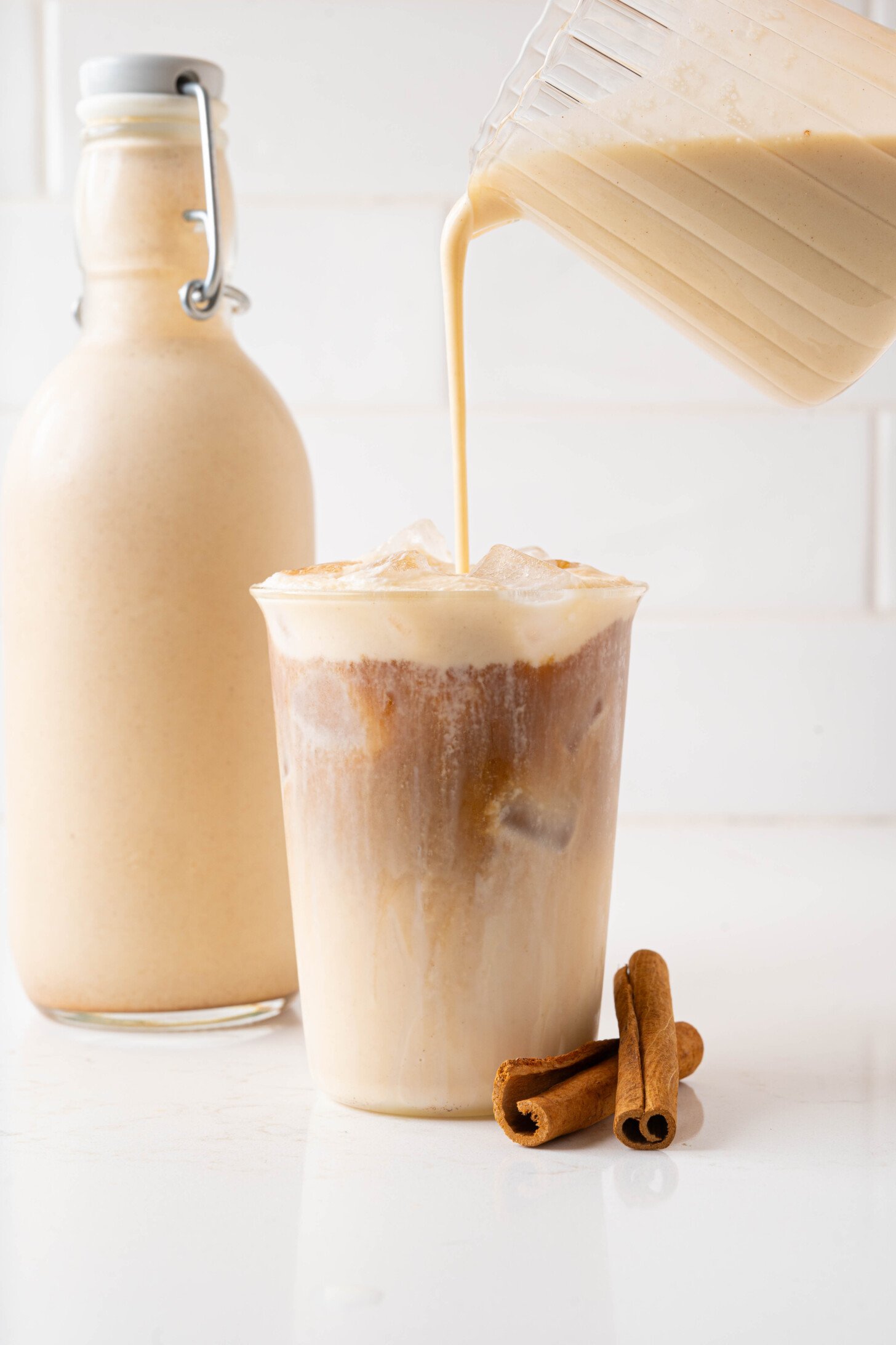 Coquito pouring over a coquito latte.