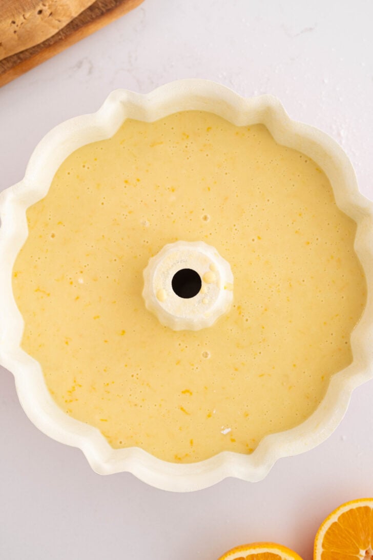 Orange cake batter in a bundt pan.