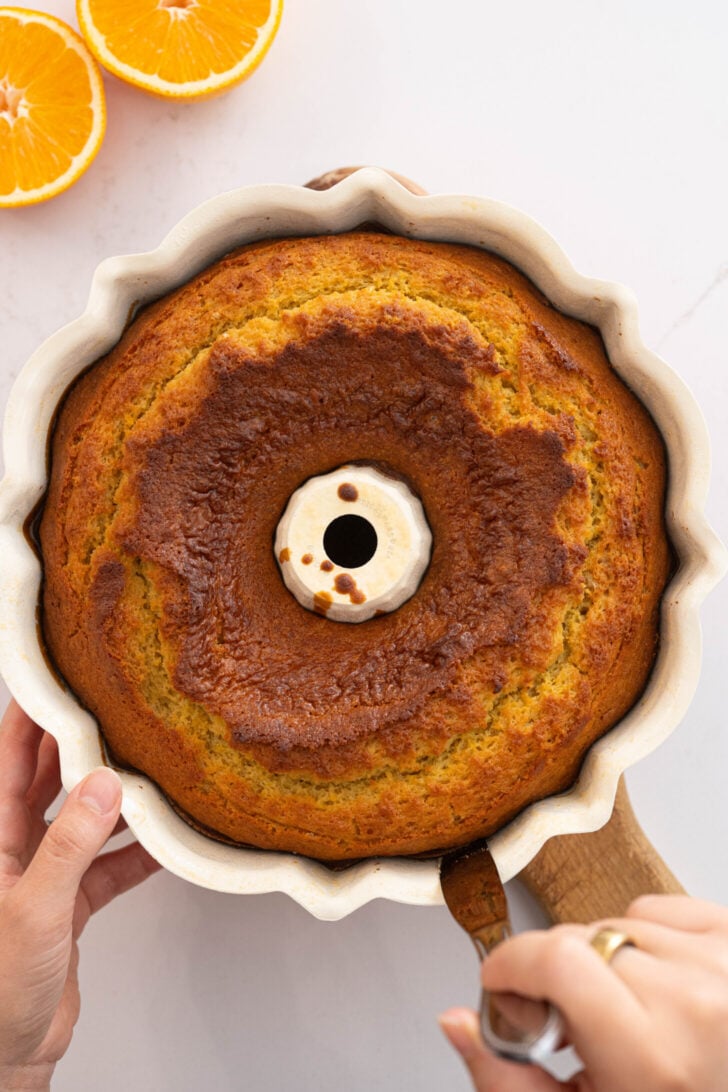 An orange bundt cake is loosening.