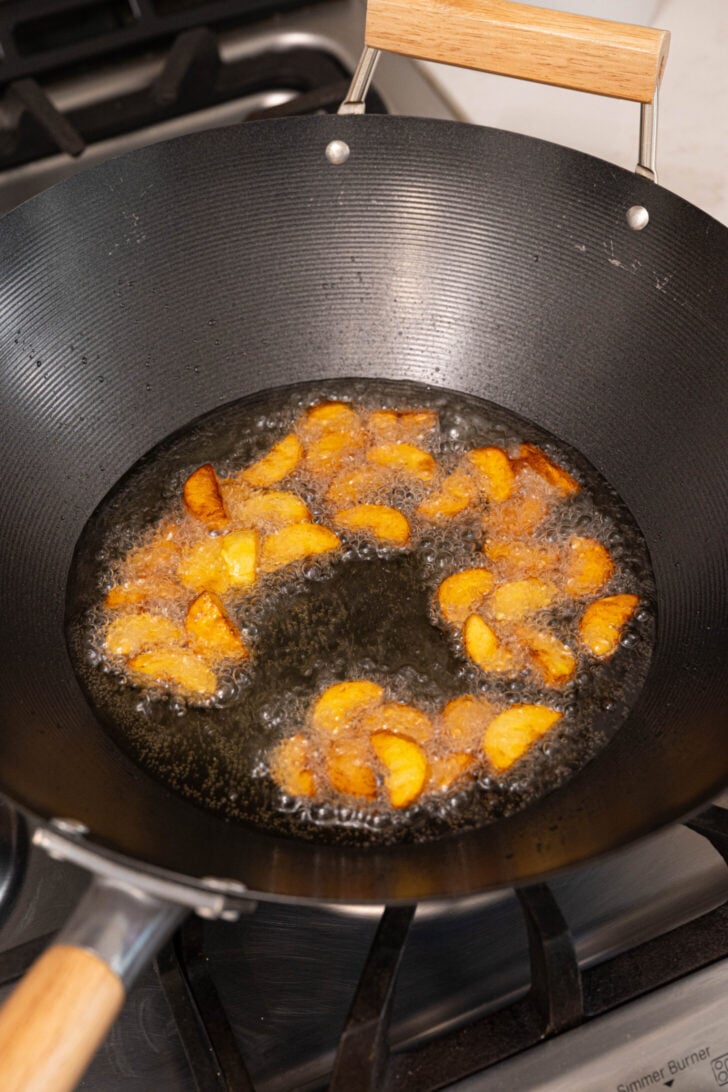 Brown plantains frying in oil.