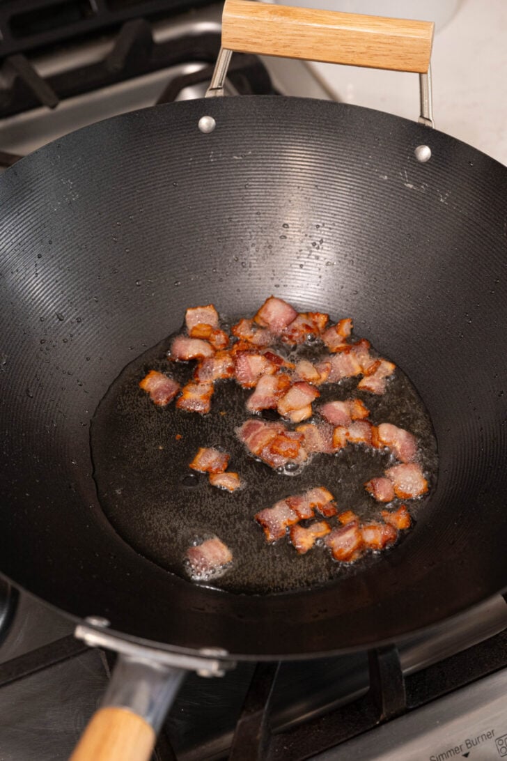 Bacon frying in a wok.