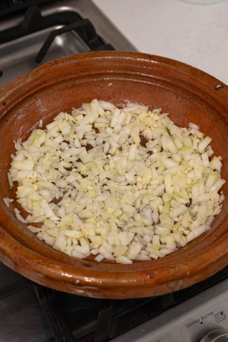 A tagine with onions and garlic.