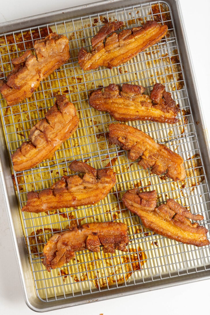 Seasoned pork belly strips on a tray.