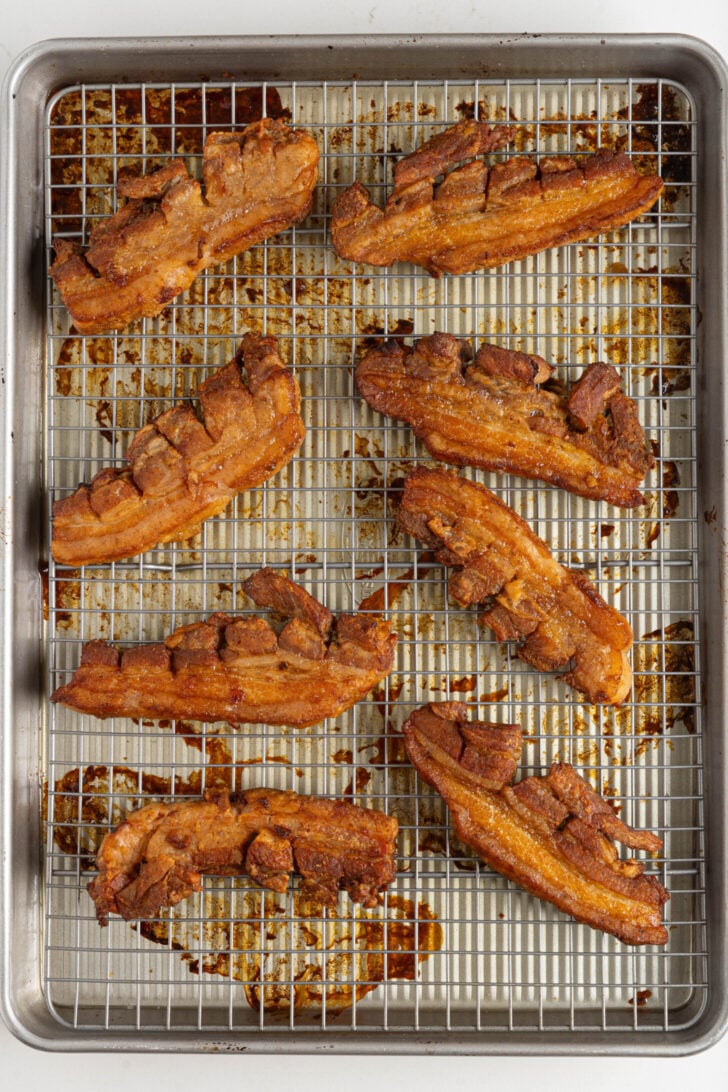 Seasoned pork belly strips on a tray.