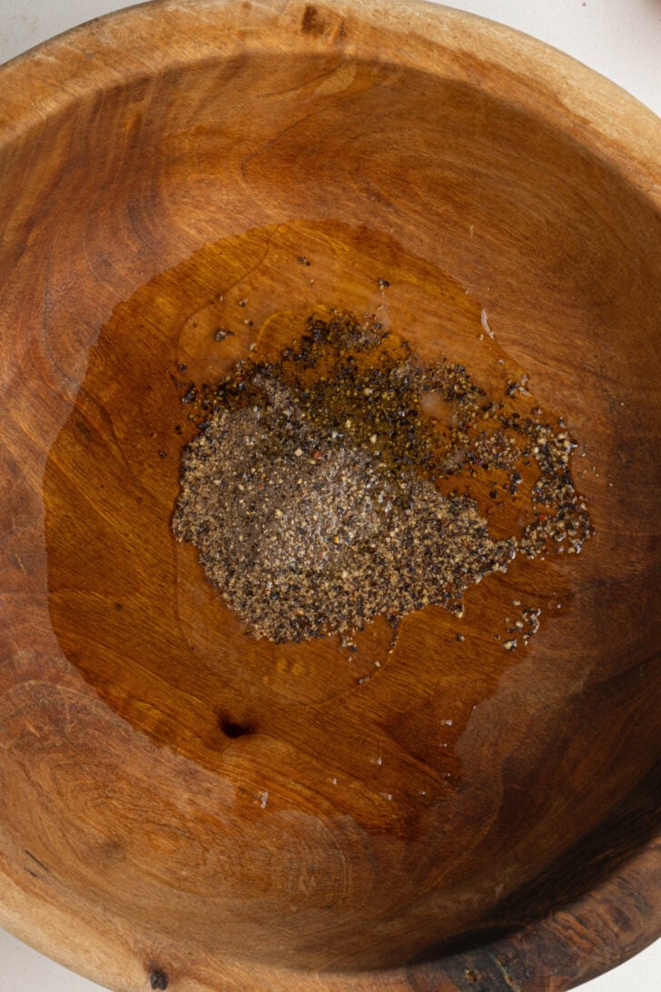 A bowl with oil, lemon juice and spices.