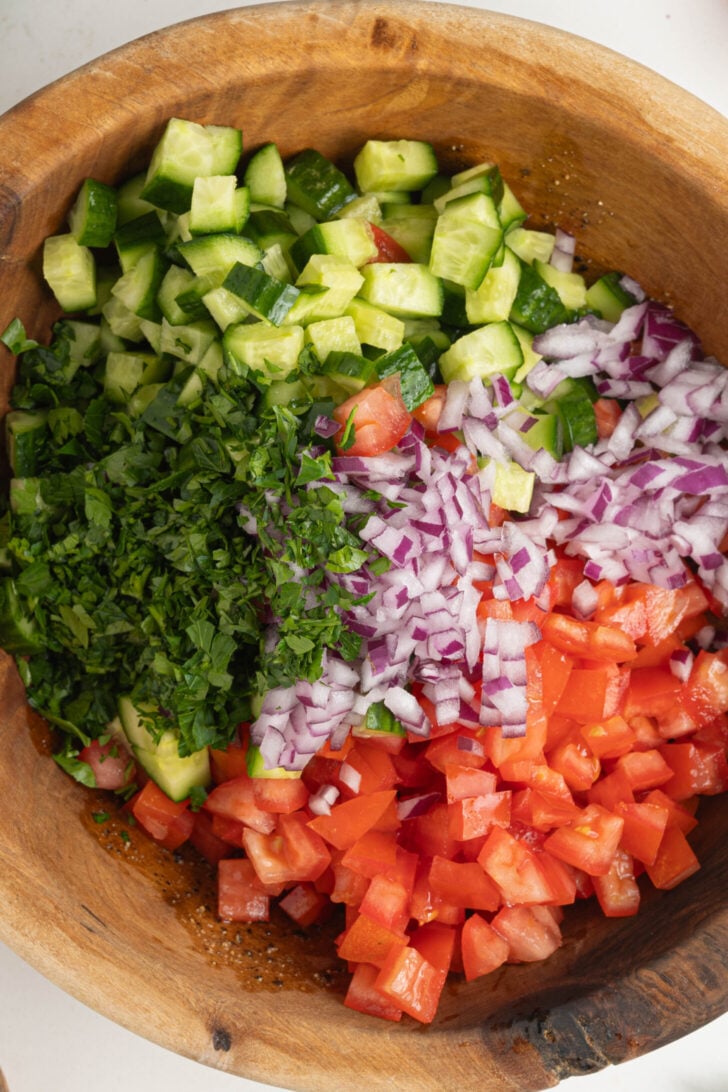 A bowl of chopped herbs and vegetables.