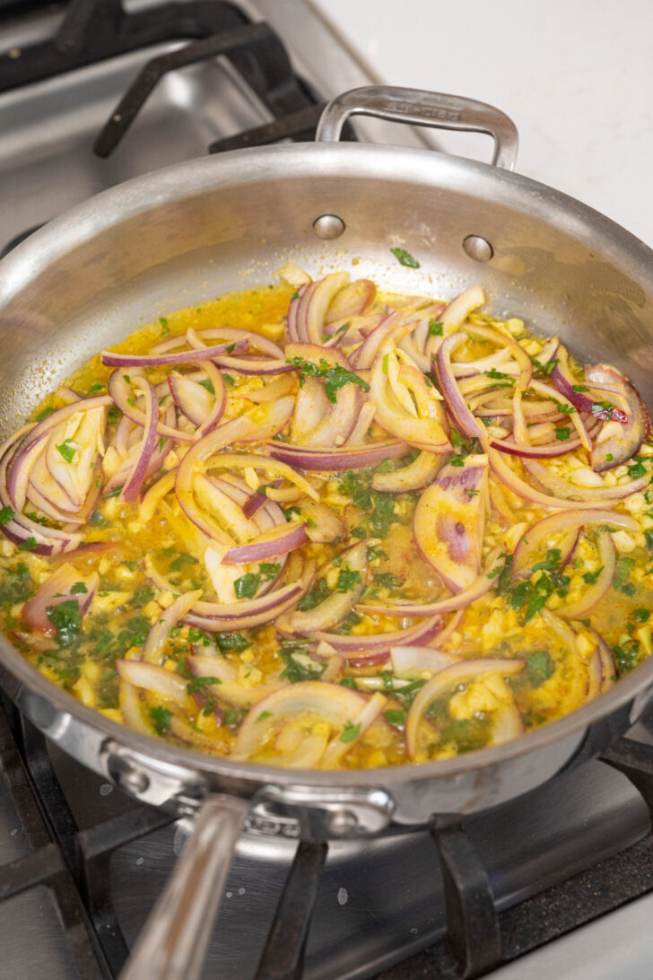 Onions with spices and oil in a pan.