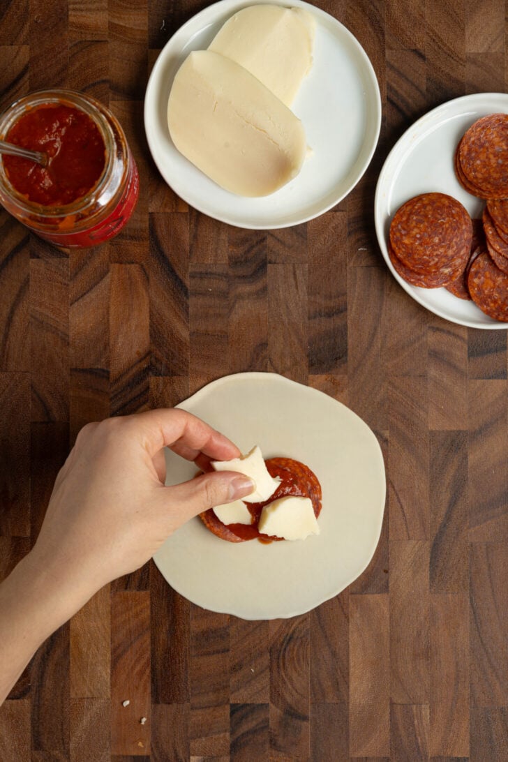 Pizza empanadas being filled.
