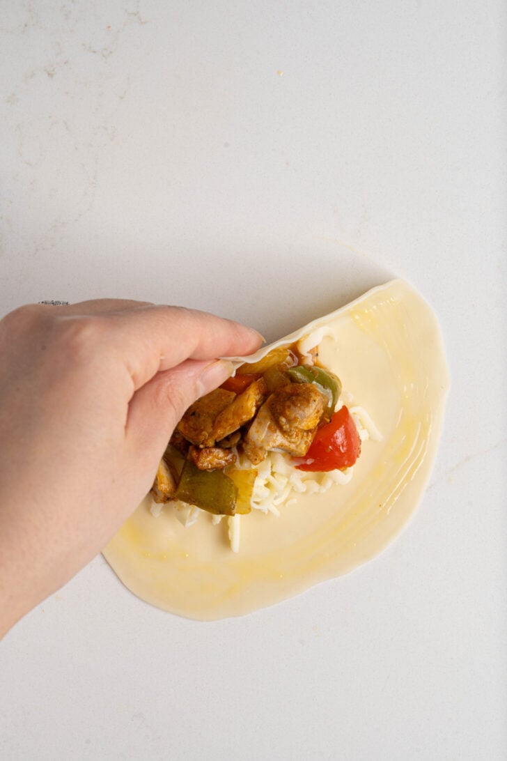 Chicken empanadas being closed.