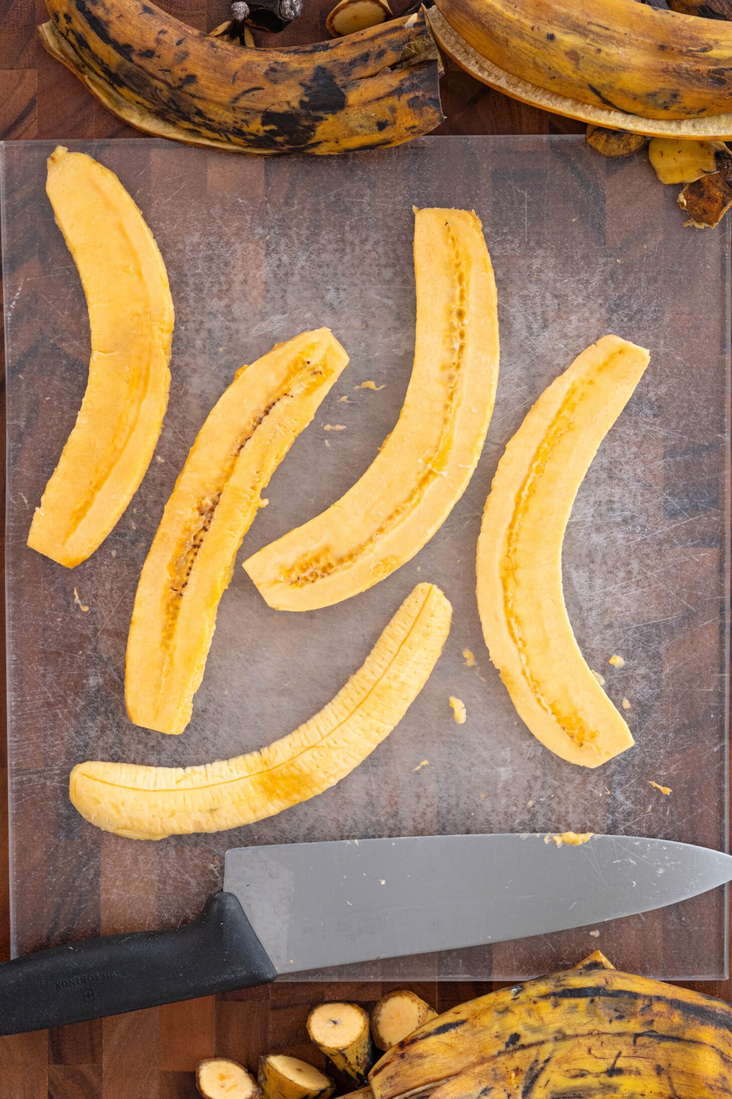 Sliced brown plantains on a cutting board.