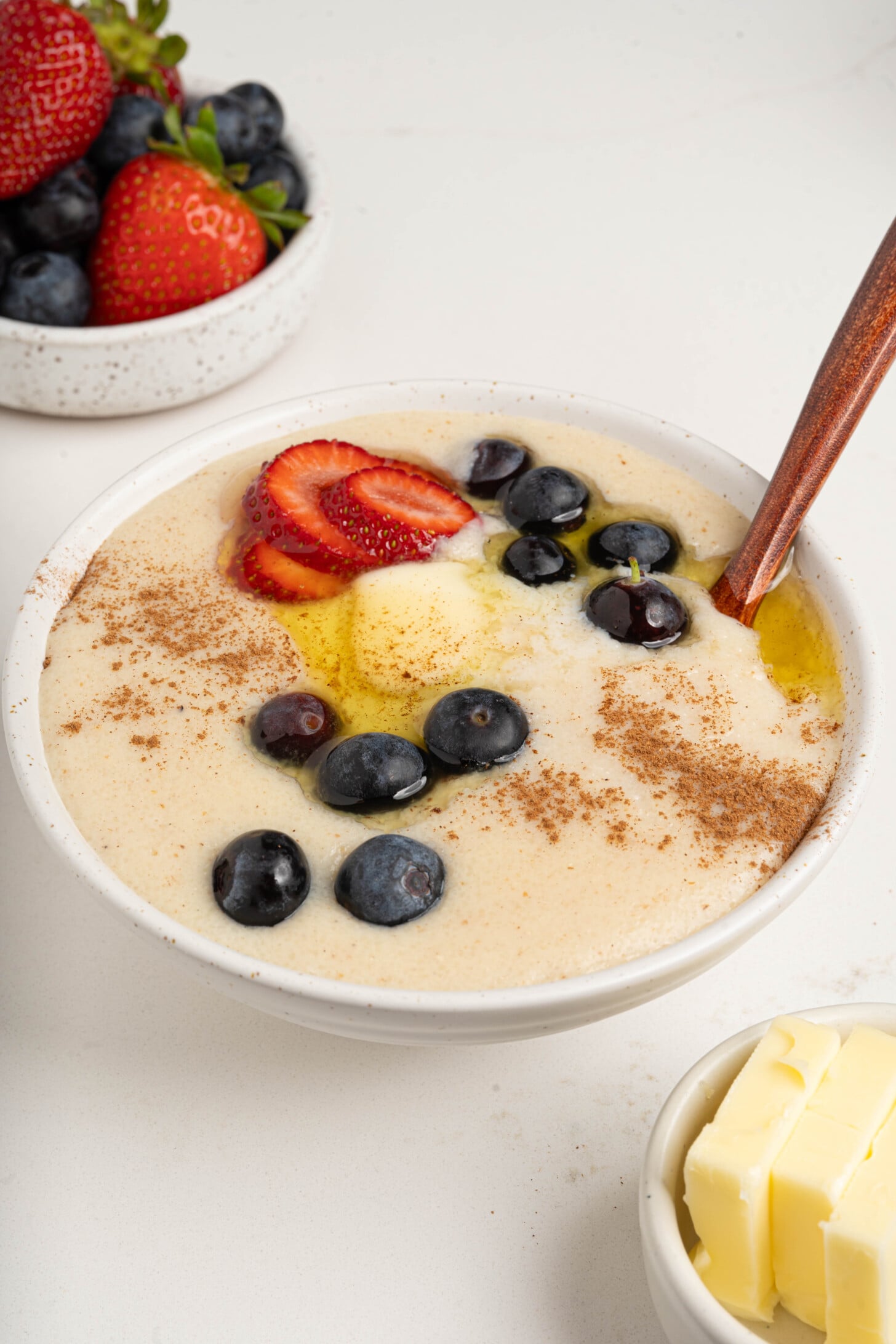 A bowl of farina with berries and butter.