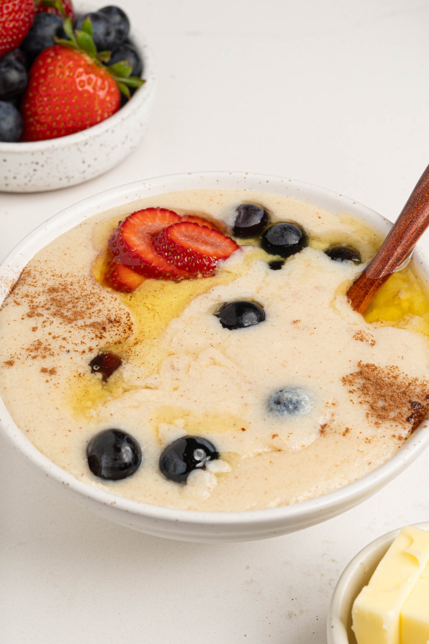 A bowl of farina with berries and butter.