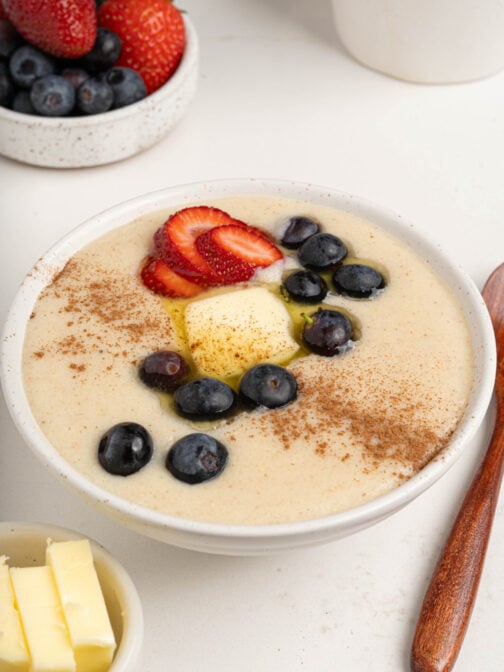 A bowl of farina with berries and butter.
