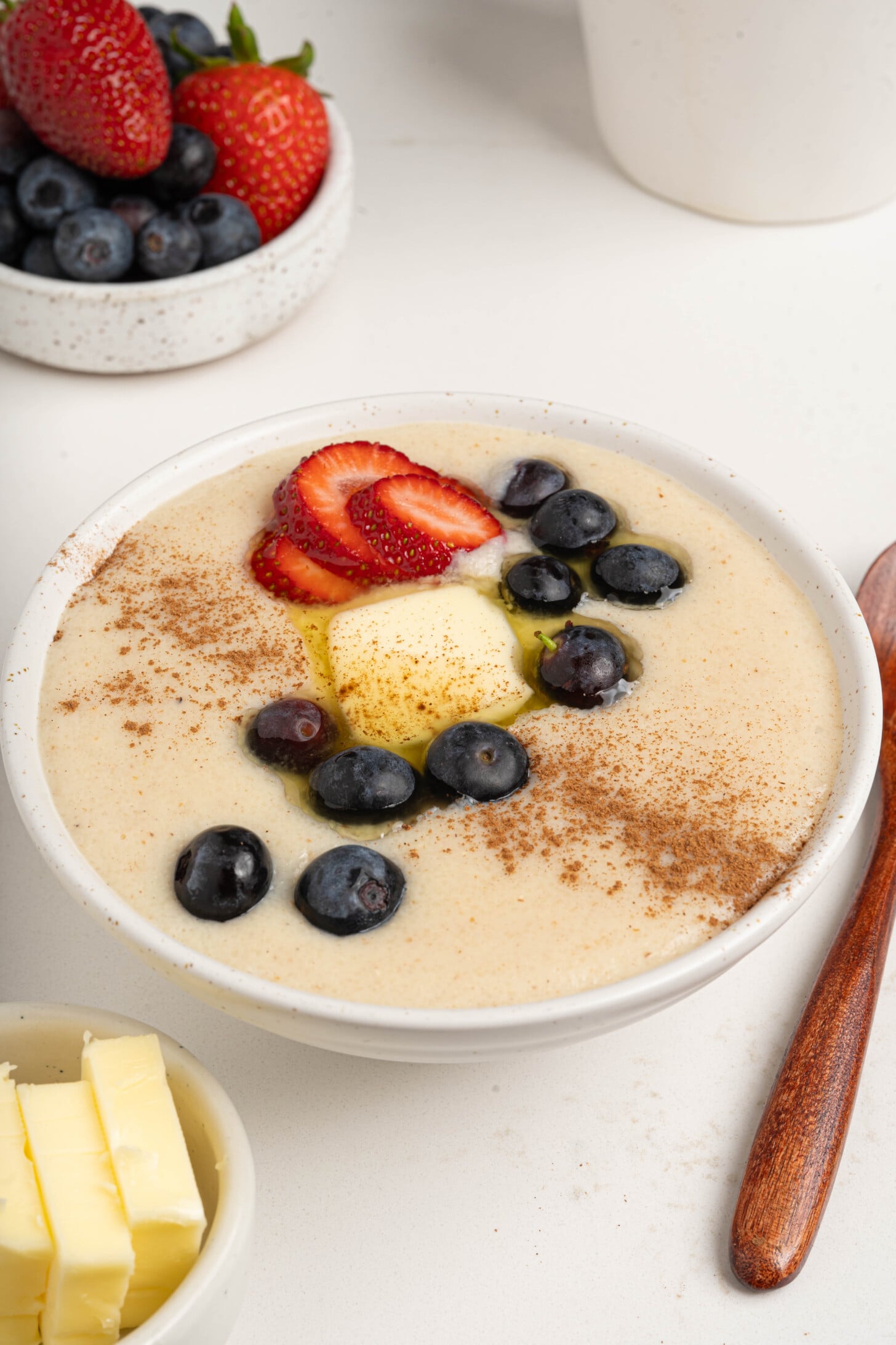 A bowl of farina with berries and butter.