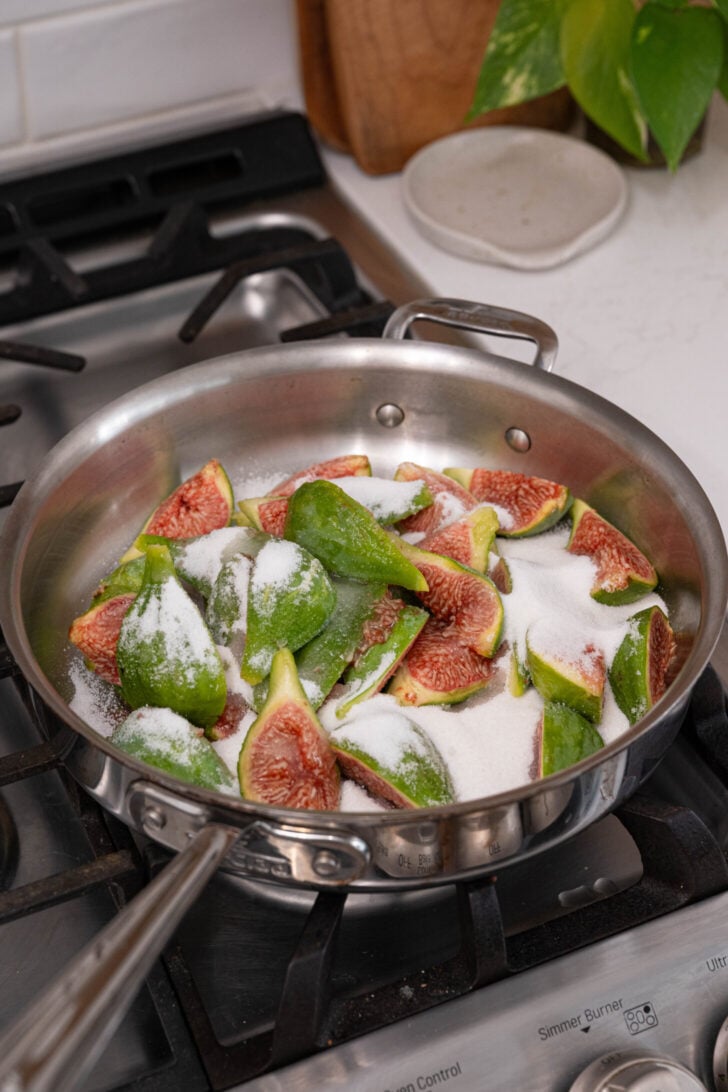 Sliced figs and sugar in a pan.