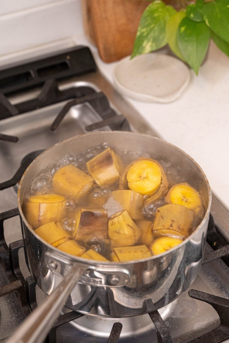 Sliced plantains boiling in water.