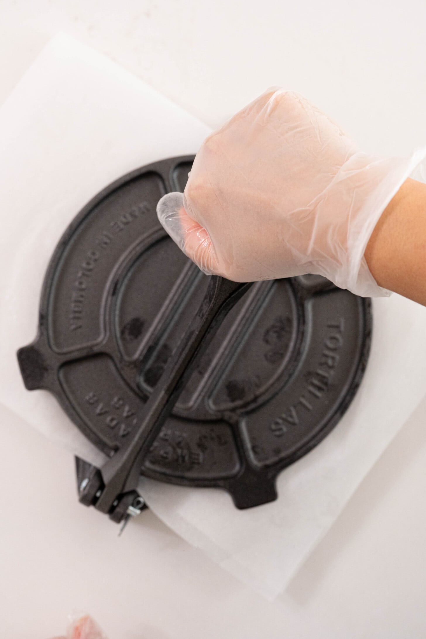 A plantain tortilla being pressed.